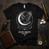 Black t-shirt with Celtic Nights Raven Spirit design featuring a raven flying near a crescent moon and constellations