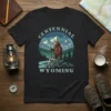 Centennial Wyoming t-shirt design featuring a brown bear standing on rocks with mountains and trees in the background