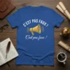 Blue t-shirt with white text "C'EST PAS FAUX !" above a yellow megaphone graphic and below with white cursive text