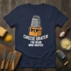 Funny "Cheese Grater The Bear Who Grates" quote on a navy t-shirt, featuring a cartoon cheese block wearing sunglasses and