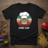 Black t-shirt featuring a graphic of a cat wearing a chef's hat and bandana, with "CHEF CAT" text below, set