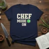 Navy t-shirt with white text "CHEF MODE ON" and a green circle icon, perfect for chefs and home cooks