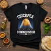 Black t-shirt with "Chickpea Connoisseur 24/7" text and a graphic of a chickpea spotlighting a cityscape