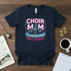 Navy t-shirt with "CHOIR MOM LIKE A NORMAL MOM ONLY COOLER" in bold pink and white text, featuring musical notes