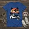 Cholo ON T-Shirt with a cartoon man in a lowrider car at sunset with palm trees