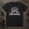 Black t-shirt with "Choose Your Weapon" text and graphic of camera lenses arranged in a circle