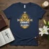 Navy t-shirt with "Christ Is King" text, lion head, and cross graphic in gold and white