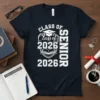 Class of 2026 Senior 2026 text with graduation cap and open book graphic on a navy blue t-shirt
