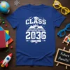 Class of 2036 graduation t-shirt design with an open book, cityscape, graduation cap, pencil, and diploma
