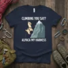 Funny alpaca climbing a mountain with text "CLIMBING YOU SAY? ALPACA MY HARNESS" on a navy t-shirt