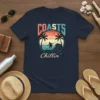 Navy t-shirt with "Coasts Chillin'" text and a vintage surfing graphic featuring palm trees and ocean waves