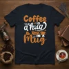 Coffee is a Hug in a Mug quote on a black t-shirt, featuring orange and white typography and coffee cup