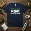 Navy t-shirt with "COMBAT MEDIC" text in camouflage and white, featuring an electrocardiogram line graphic
