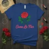 Como La Flor t-shirt with a red rose graphic and pink script text, Spanish phrase design