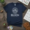 Concierge Bloom Creative Gardens text with floral illustration on a navy blue t-shirt