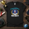 Congratulations YOU DID IT t-shirt with a rocket launching through clouds, surrounded by a laurel wreath