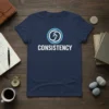 Navy blue t-shirt with the word CONSISTENCY in white text and a circular arrow graphic above