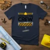 Navy blue t-shirt with "CONSTRUCTION CREW" text, hard hat graphic, and caution tape design elements