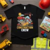 Black t-shirt with "Construction Crew" text and cartoon construction vehicles like a dump truck and excavator, designed for kids