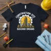 Construction Site Building Dreams t-shirt with graphic of buildings, cranes, and workers