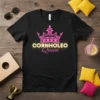 Cornholeo Queen t-shirt design featuring a pink crown and neon-yellow text for "CORNHOLEO" and pink script for "Queen"
