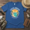 Costa Brava Catalonia t-shirt design featuring a circular graphic of a scenic coastline, sun, and the Catalan flag. Includes text
