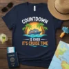 T-shirt with "COUNTDOWN IS OVER IT'S CRUISE TIME" text, featuring a cruise ship, palm trees, and ocean sunset graphic