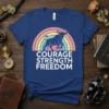 Courage Strength Freedom t-shirt with a dark blue bull silhouetted against a pastel rainbow. Bold white text reads "COURAGE STRENGTH