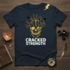 Cracked Strength t-shirt with a gold skull graphic, lightning bolt, and black birds, featuring white text "CRACKED STRENGTH"