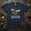 T-shirt with "Crafted By Hand Made To Last" text and graphic of hands working on an anvil