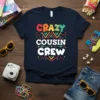 Navy blue t-shirt with colorful "CRAZY COUSIN CREW" text design featuring geometric patterns and arrows