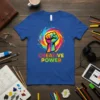 Blue t-shirt with "CREATIVE POWER" text and a colorful fist graphic, representing artistic energy and inspiration