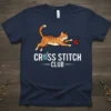 Cross Stitch Club t-shirt design featuring a cartoon cat playing with yarn and embroidery tools