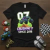 Black t-shirt with "07 CRUSHING IT SINCE 2018" text and a purple monster truck graphic jumping over a dirt mound