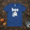 Cute white ghost with "boo" text and haunted house graphic on a royal blue t-shirt, perfect for Halloween