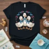 Cute Duckling Trio T-Shirt featuring three white ducklings with blue bows inside a floral wreath graphic