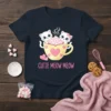 Cutie Meow Meow text with two white kittens in a yellow coffee cup graphic on a navy t-shirt