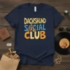 Dachshund SOCIAL CLUB text design with a cartoon dachshund playing a guitar, on a navy blue t-shirt