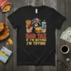 Dad Tax If I'm Buying I'm Trying text on a black t-shirt featuring a cartoon raccoon in sunglasses holding fries