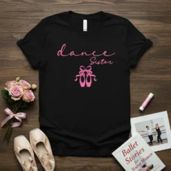 Black t-shirt with pink "dance Sister" text and ballet slippers graphic, featuring a script font and ribbon bow