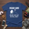 T-shirt with "Dear Abs Maybe One Day We Will Meet" text and a cartoon character climbing a mountain toward the