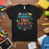 Dear Parents, Tag! You're It! The Teachers text with school-themed graphics on a black t-shirt