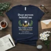 Navy t-shirt with "Dear person behind me" quote and graphic of two people connected by hearts. Includes text "The world