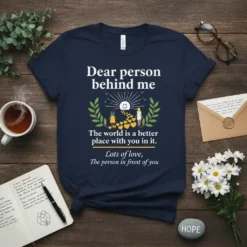 Navy t-shirt with "Dear person behind me" quote and graphic of two people connected by hearts. Includes text "The world