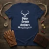 Deer Creek Antlers text design with a deer head graphic and decorative arrow on a navy t-shirt