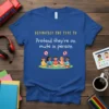 Blue t-shirt with yellow and white text "DEFINITELY THE TYPE TO Pretend they're on mute in person" and cartoon children
