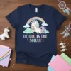 Delulu Is The Solulu text with a cute unicorn and rainbow graphic on a navy t-shirt