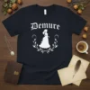 Demure text above a white silhouette of a woman in a formal gown and tiara, framed by floral elements, on