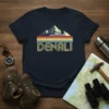 Retro Denali t-shirt design with vintage mountain graphic and striped accent, navy blue tee