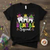 DENTAL Squad text in colorful Mardi Gras theme with three cartoon teeth wearing masks and hats, on a black t-shirt